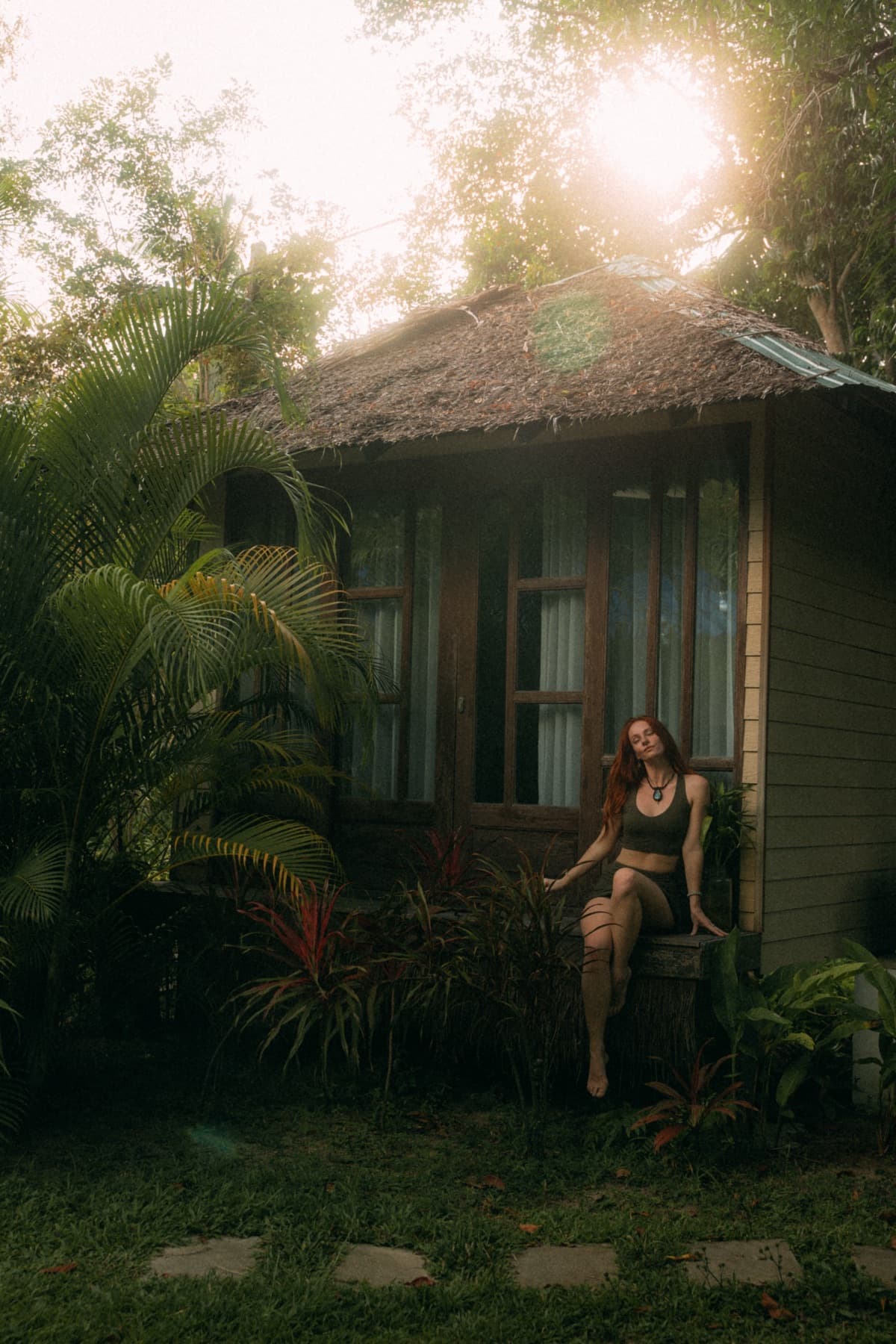 Guest resting by a jungle bungalow at golden hour